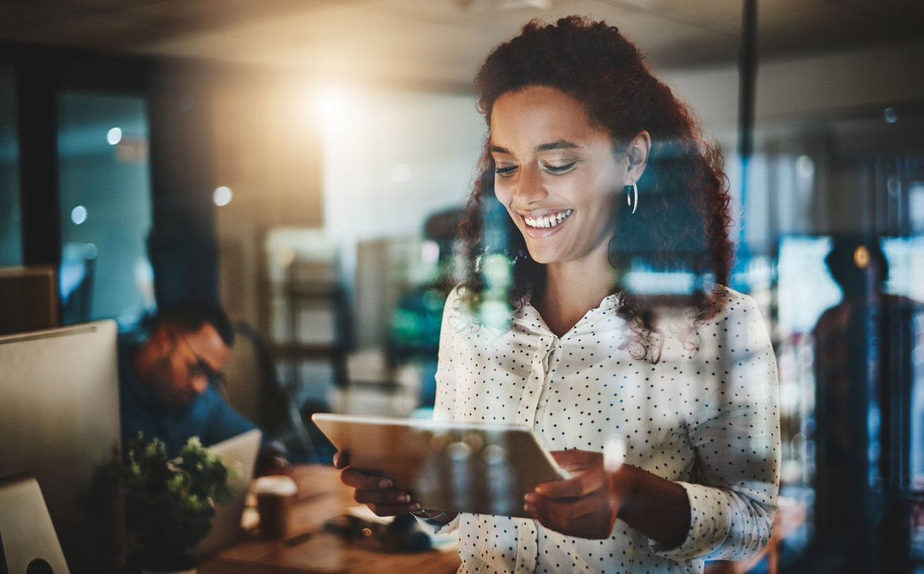 Shot of a young businesswoman using a digital tablet during a late night at work