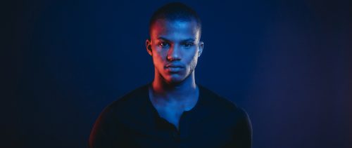 Studio portrait of a young adult man with colorful lights