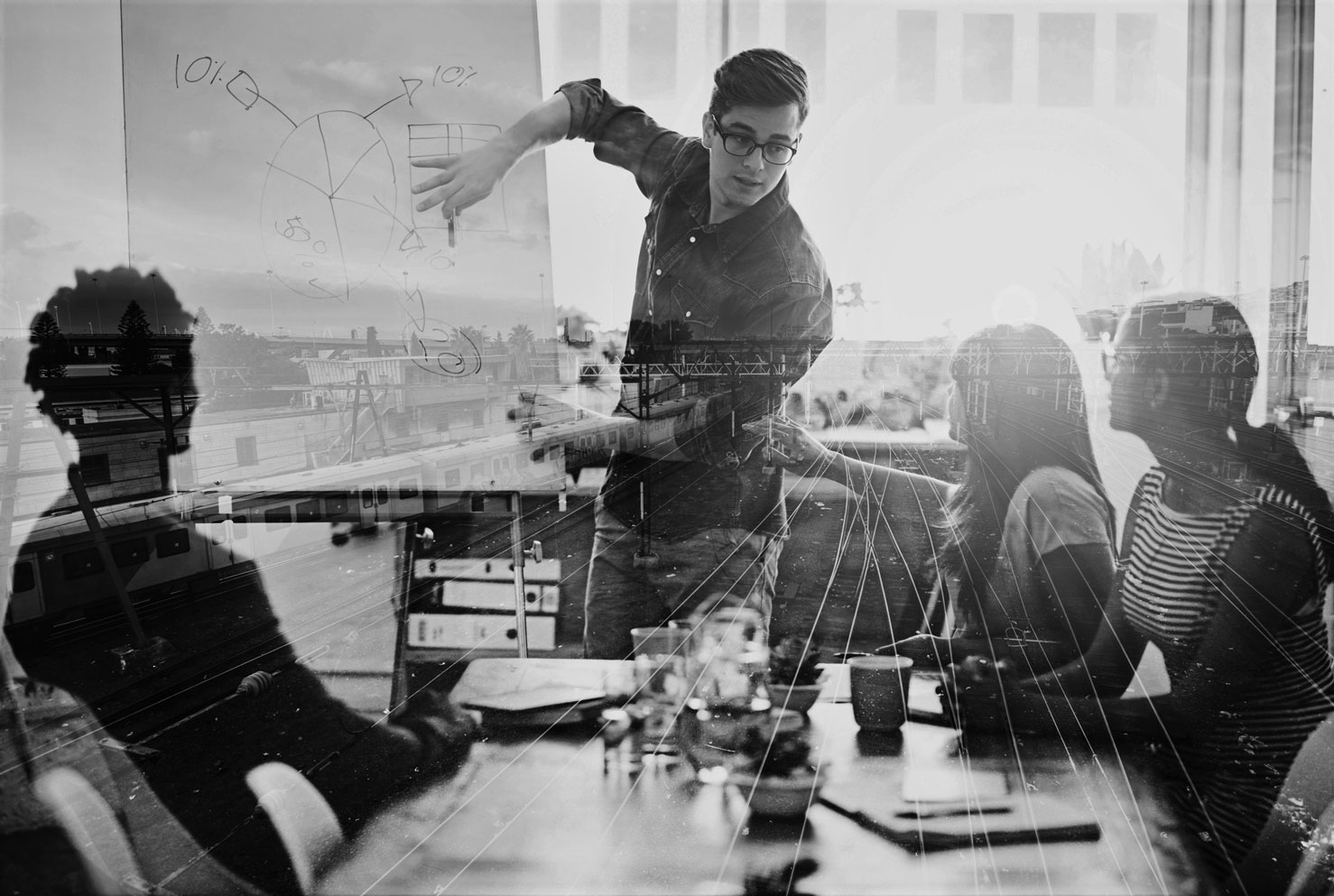 Multiple exposure shot of a business group superimposed over a train track