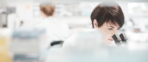 female scientist in a busy research lab