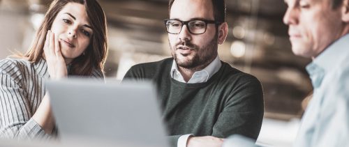 Young couple and real estate agent using laptop on a meeting in the office.