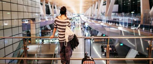 Young woman with a suitcase traveling solo on the Qatar airport